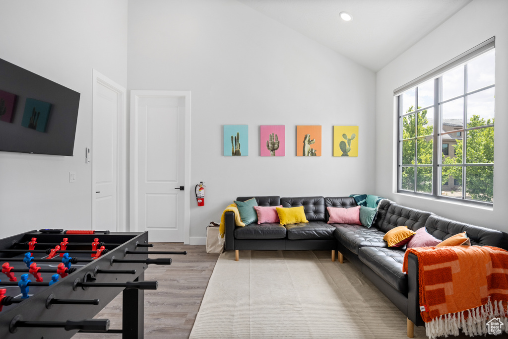 Living room featuring vaulted ceiling and light hardwood / wood-style flooring