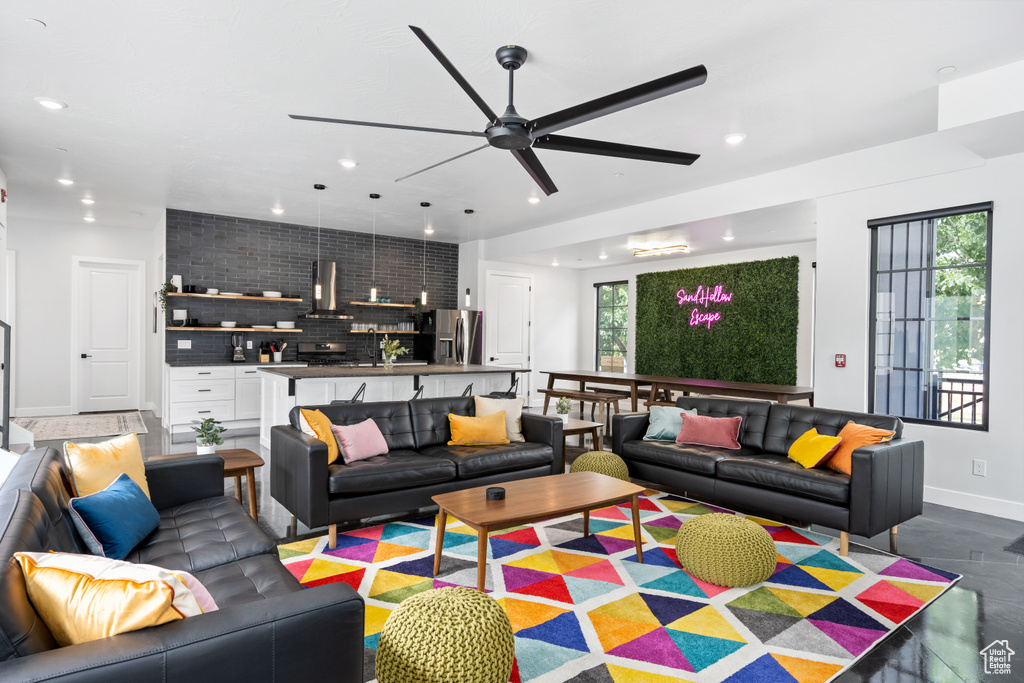 Living room with ceiling fan, concrete flooring, and a healthy amount of sunlight