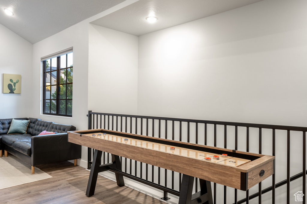 Recreation room featuring vaulted ceiling and light hardwood / wood-style flooring