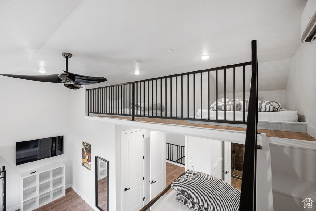 Stairway with ceiling fan and wood-type flooring