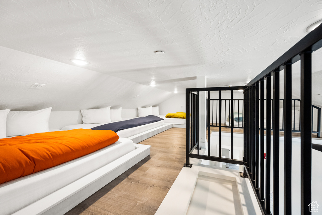 Bedroom with vaulted ceiling and light wood-type flooring