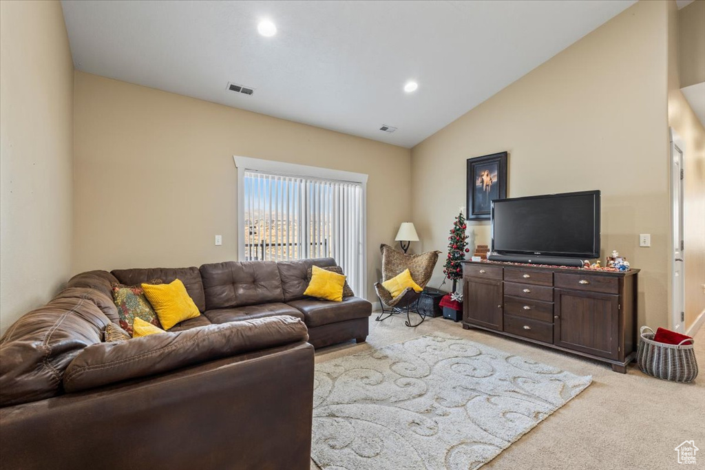 Carpeted living room featuring vaulted ceiling