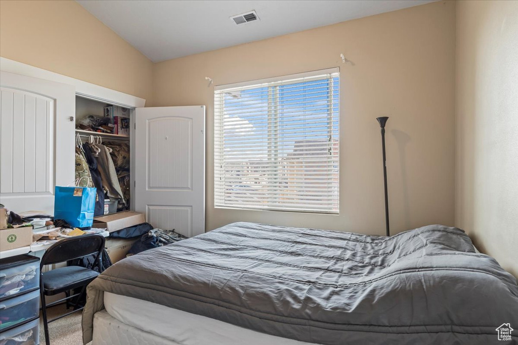 Bedroom featuring a closet and lofted ceiling