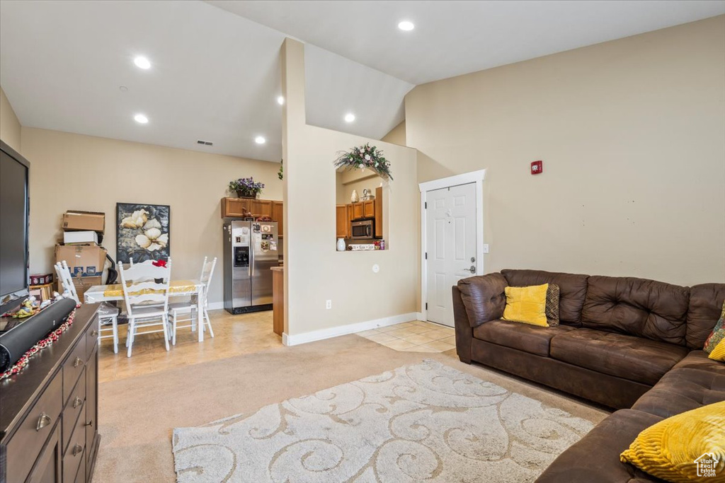 Living room with vaulted ceiling and light tile patterned floors