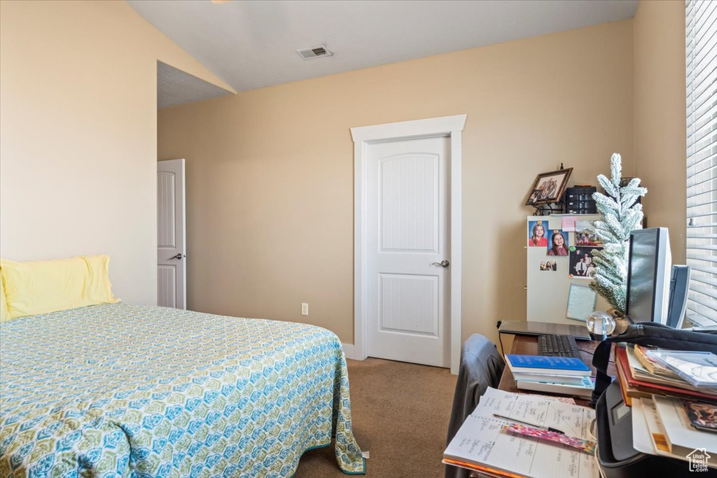 Carpeted bedroom featuring vaulted ceiling