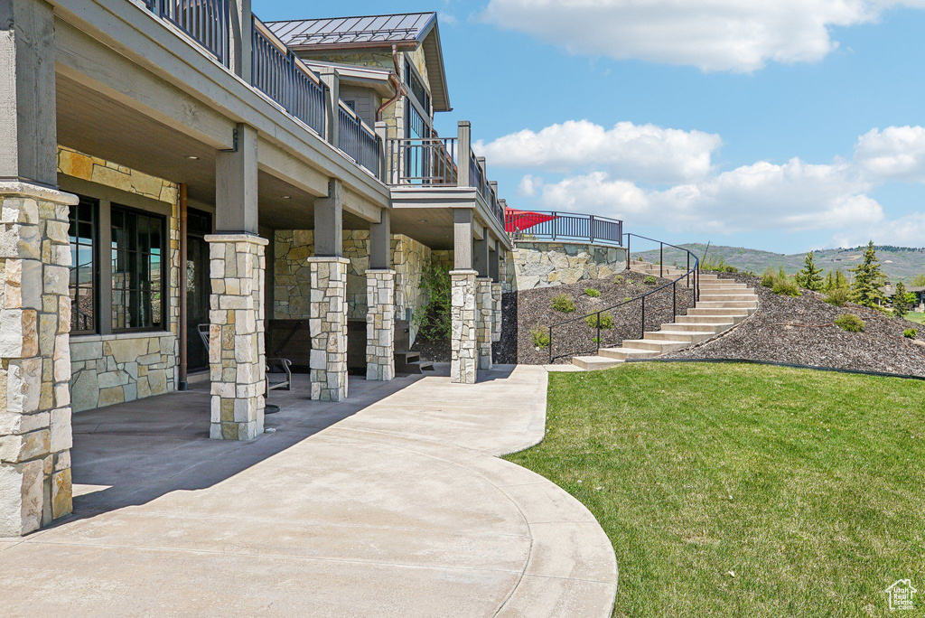 View of home's community featuring stairway, a yard, and a mountain view