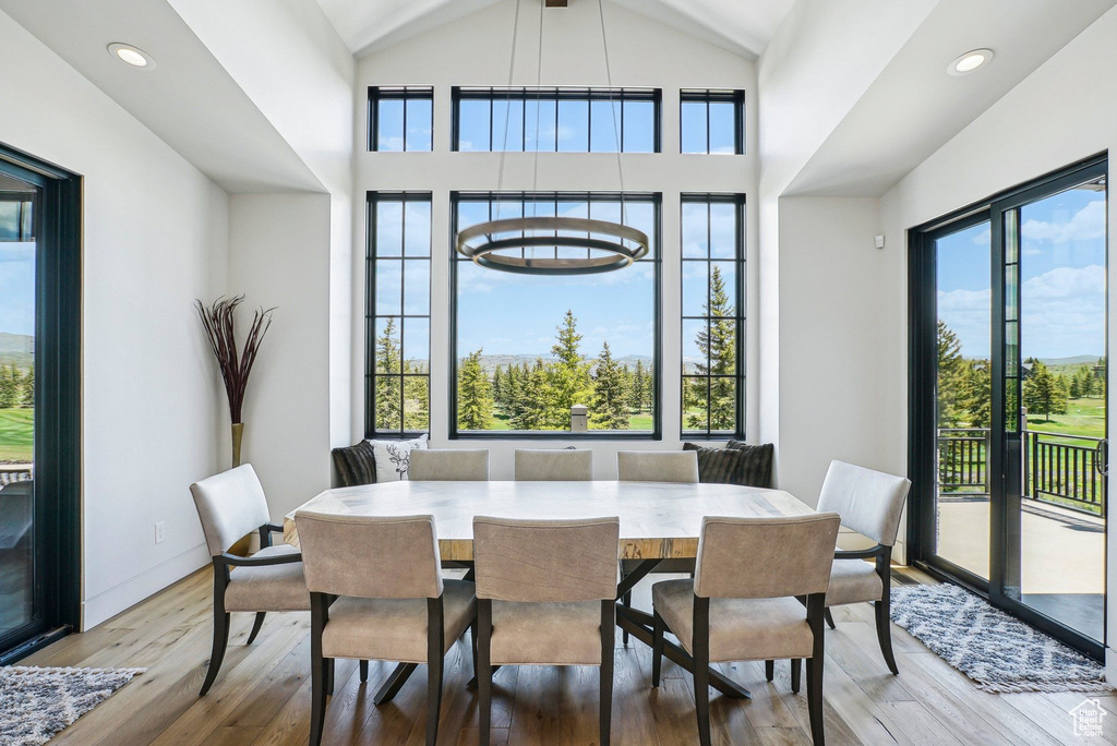 Dining space featuring wood finished floors, lofted ceiling, and recessed lighting