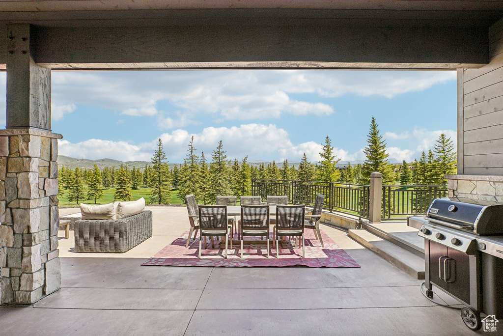 View of patio with outdoor dining space, a mountain view, and area for grilling