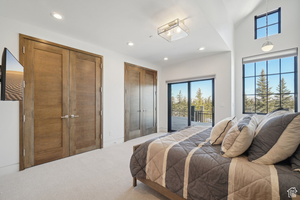 Bedroom with access to exterior, multiple windows, light carpet, and recessed lighting