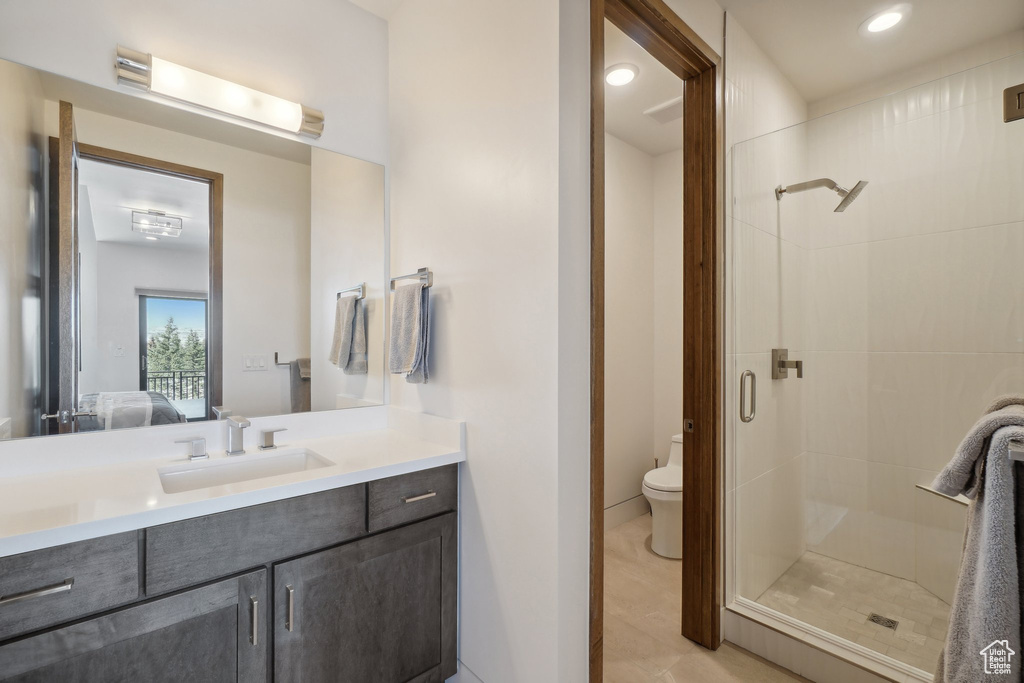 Ensuite bathroom with a shower stall, vanity, toilet, and recessed lighting