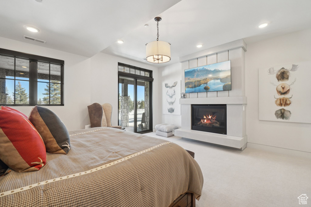 Bedroom with carpet, recessed lighting, and a glass covered fireplace