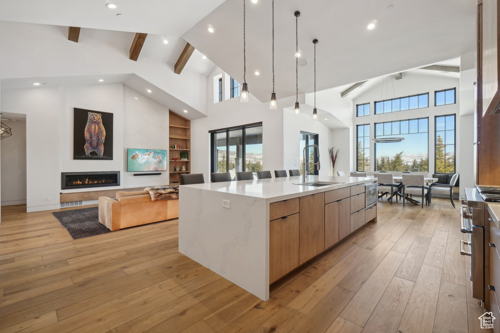 Kitchen featuring modern cabinets, a sink, high vaulted ceiling, open floor plan, and beam ceiling