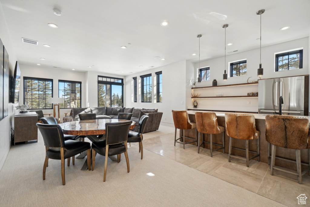 Dining space with recessed lighting, healthy amount of natural light, and bar area