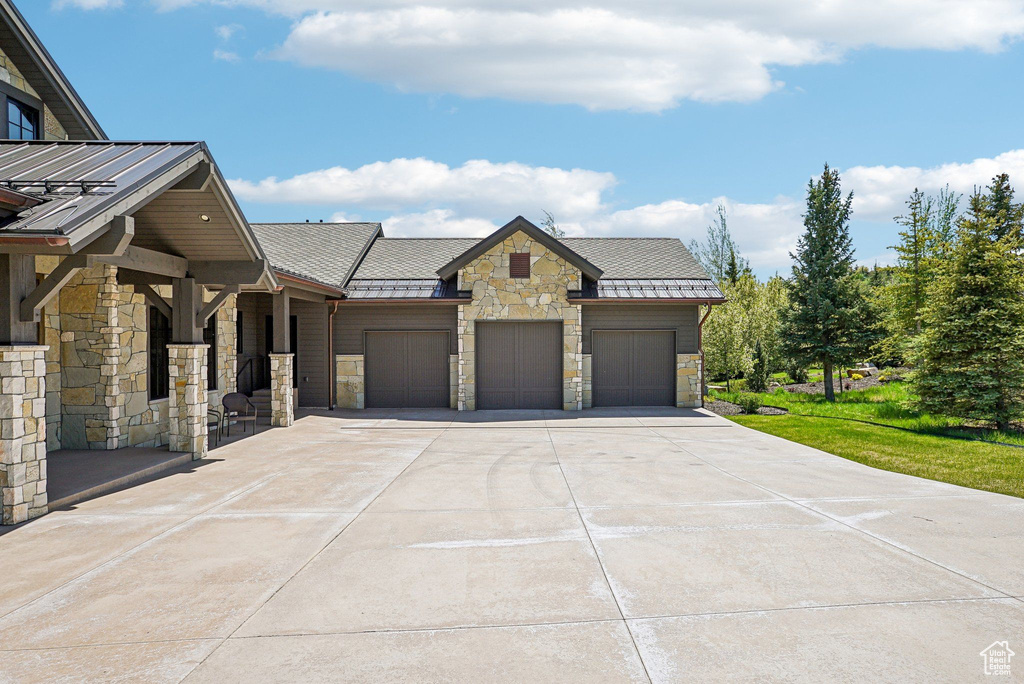 View of front of home featuring stone siding, a standing seam roof, and metal roof