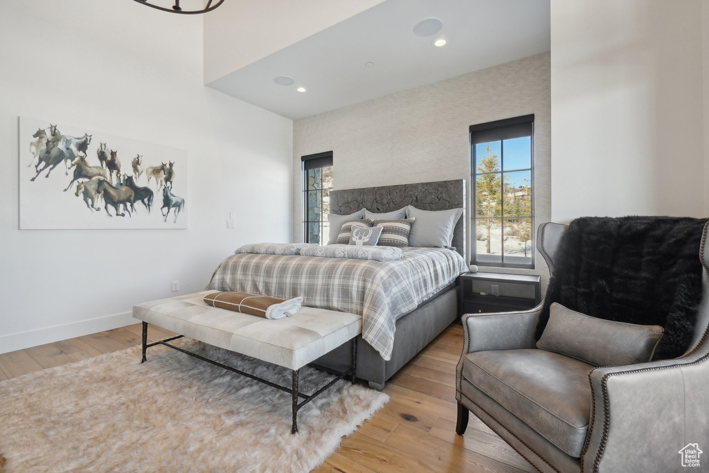 Bedroom with multiple windows, light wood-style flooring, baseboards, and recessed lighting