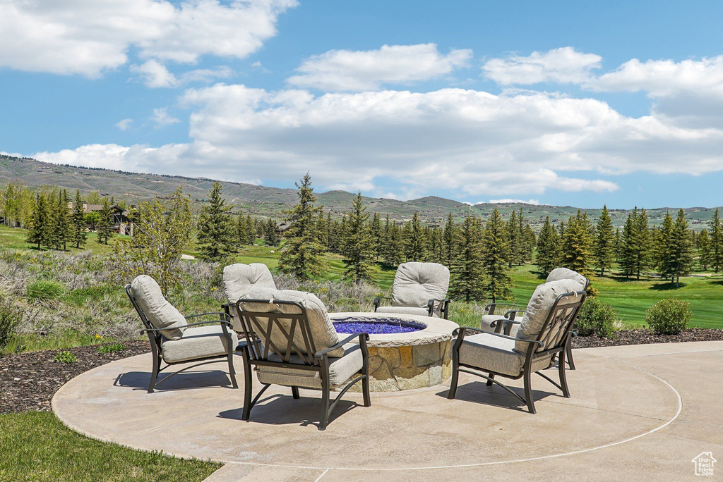 View of patio / terrace with a mountain view and an outdoor fire pit