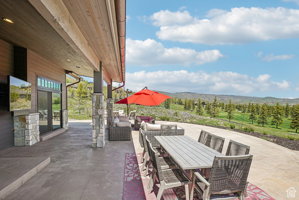 View of patio / terrace featuring a mountain view, outdoor dining area, and an outdoor hangout area