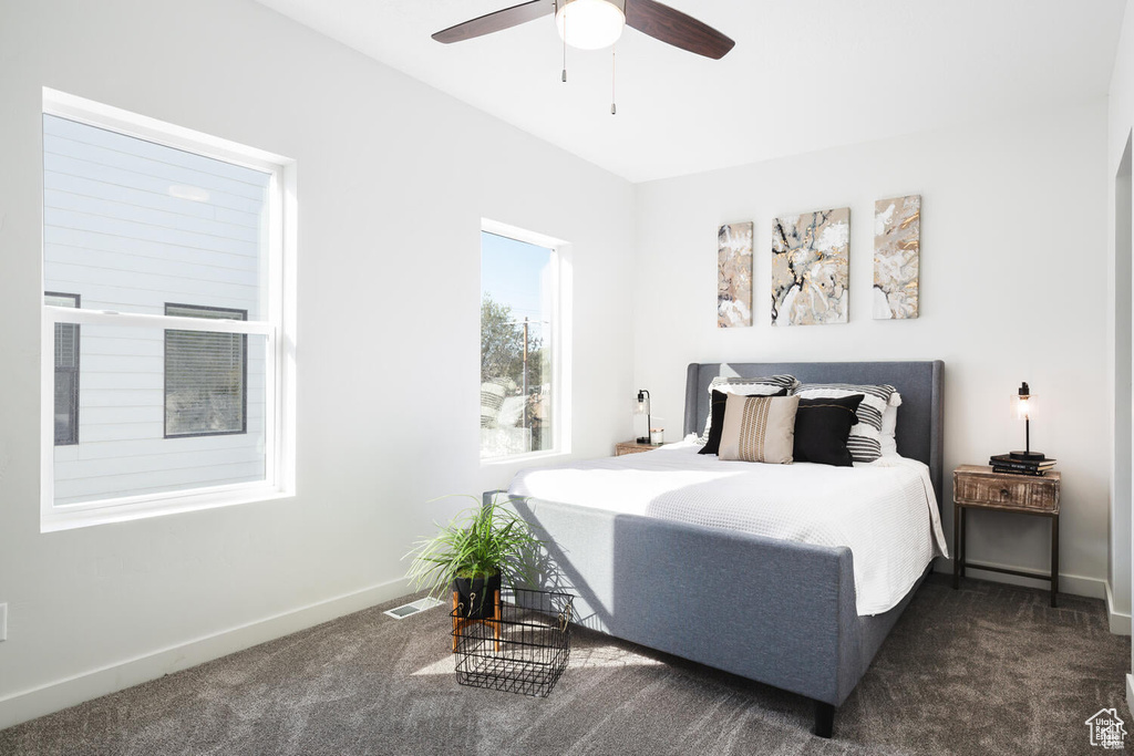 Bedroom featuring ceiling fan and dark colored carpet