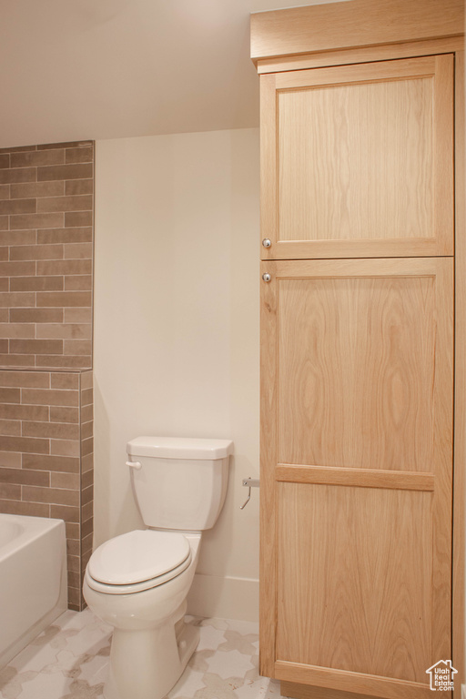 Bathroom featuring a bath and toilet