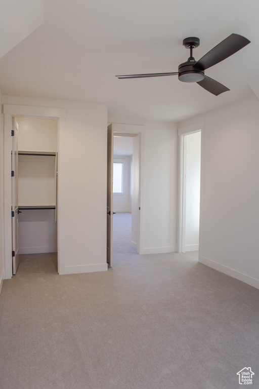 Unfurnished bedroom featuring light carpet and ceiling fan