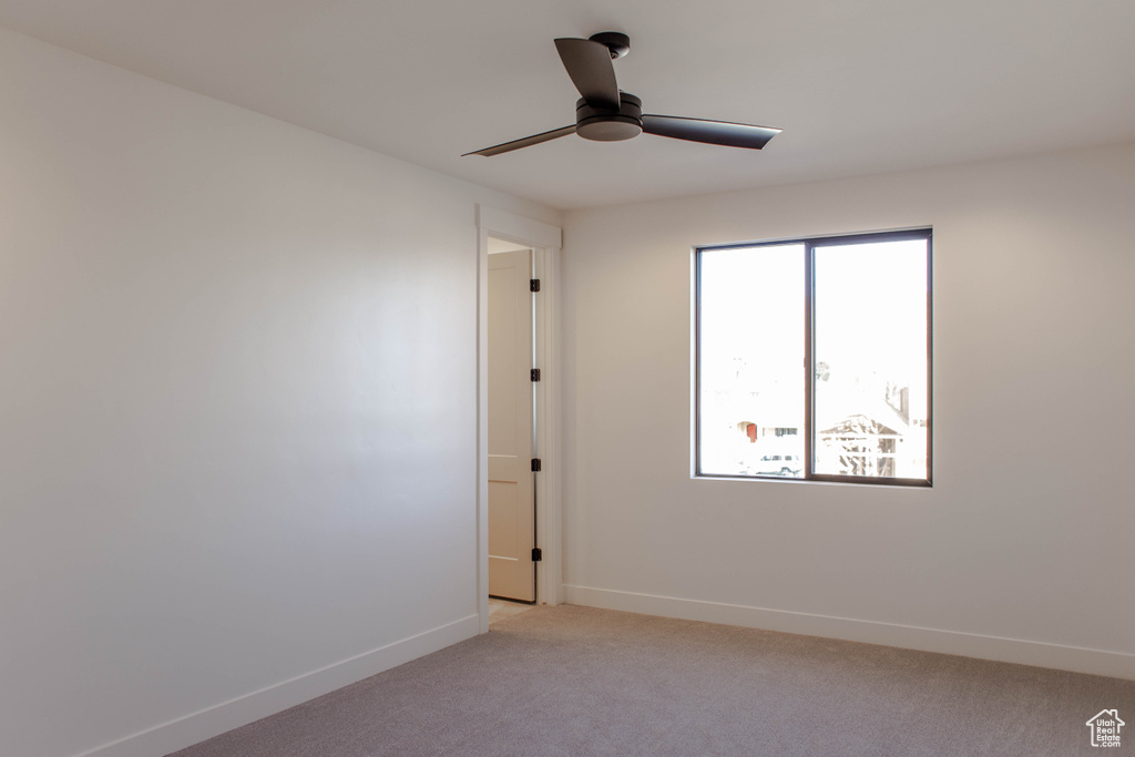 Carpeted spare room with ceiling fan