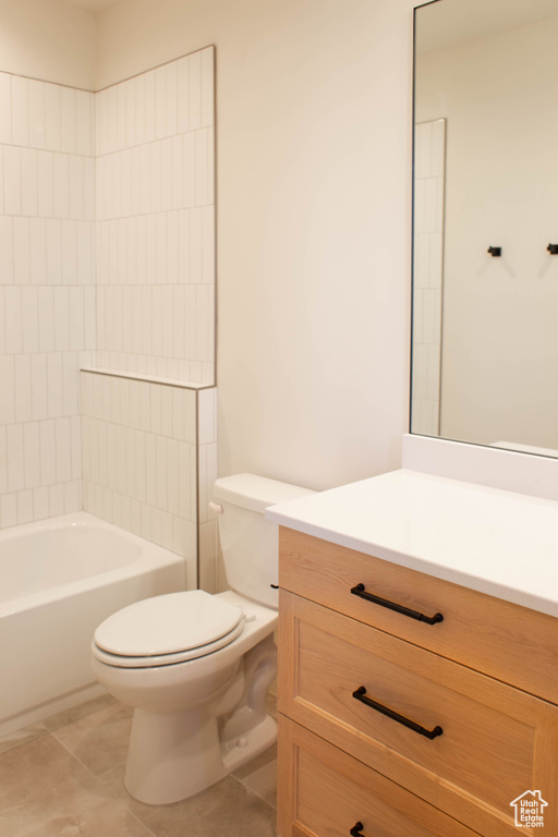 Full bathroom with tiled shower / bath combo, vanity, tile patterned floors, and toilet