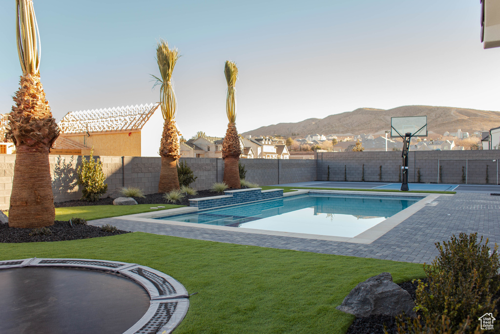 View of pool with a mountain view and a yard