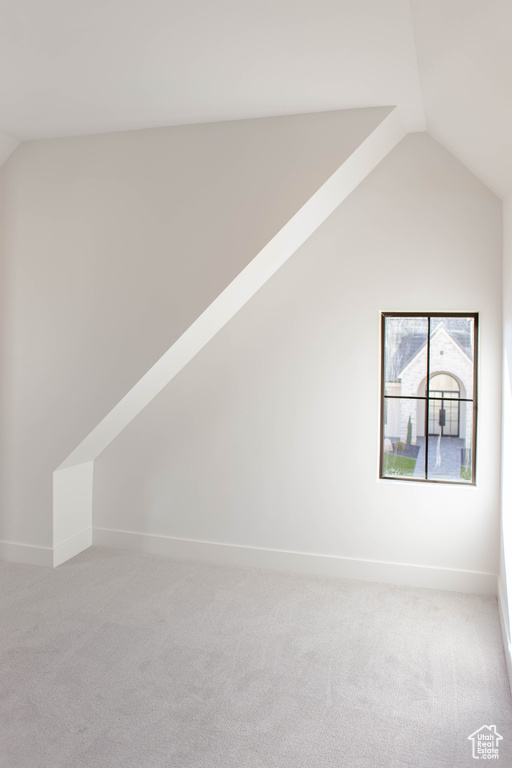 Bonus room featuring vaulted ceiling and light carpet