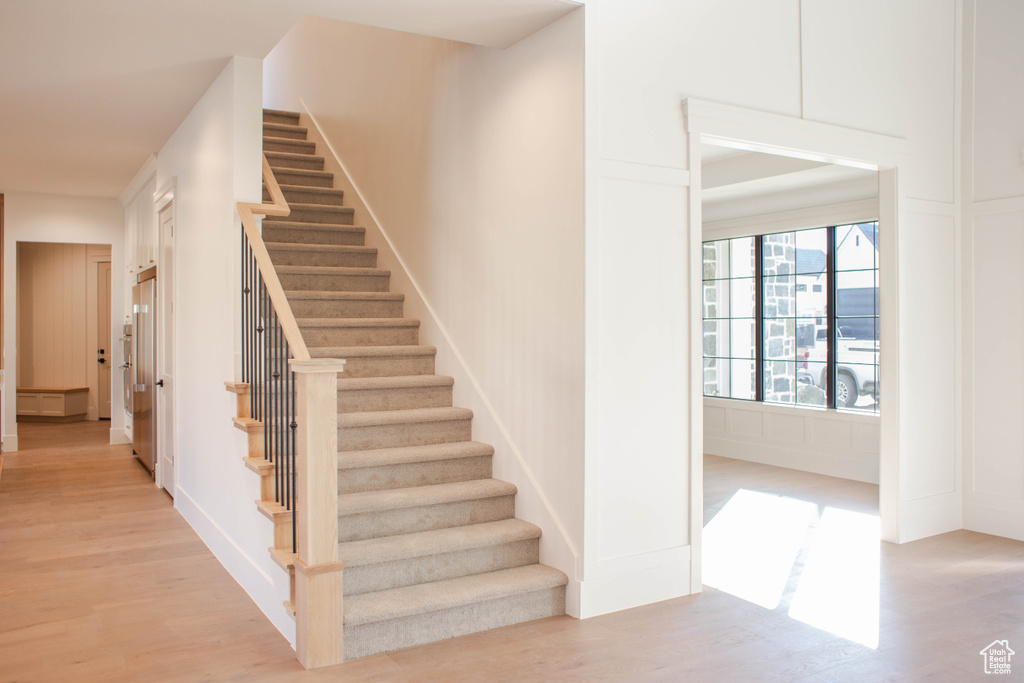 Staircase featuring hardwood / wood-style flooring