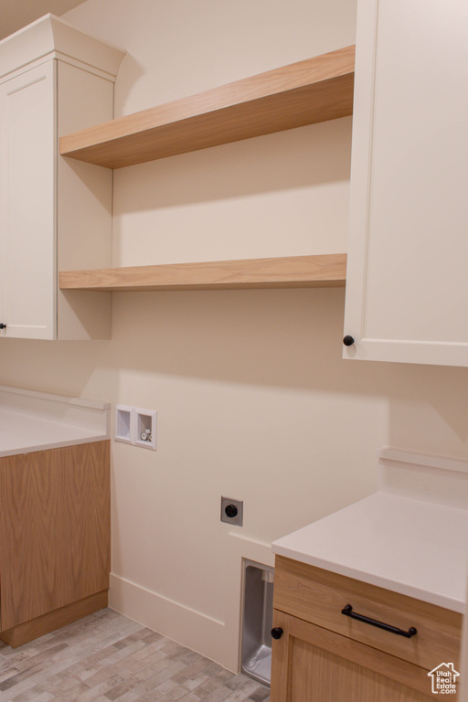 Laundry room featuring washer hookup, cabinets, hookup for an electric dryer, and light wood-type flooring