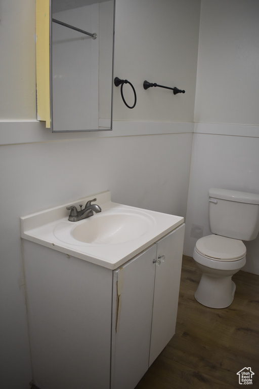 Bathroom with toilet, vanity, and hardwood / wood-style flooring