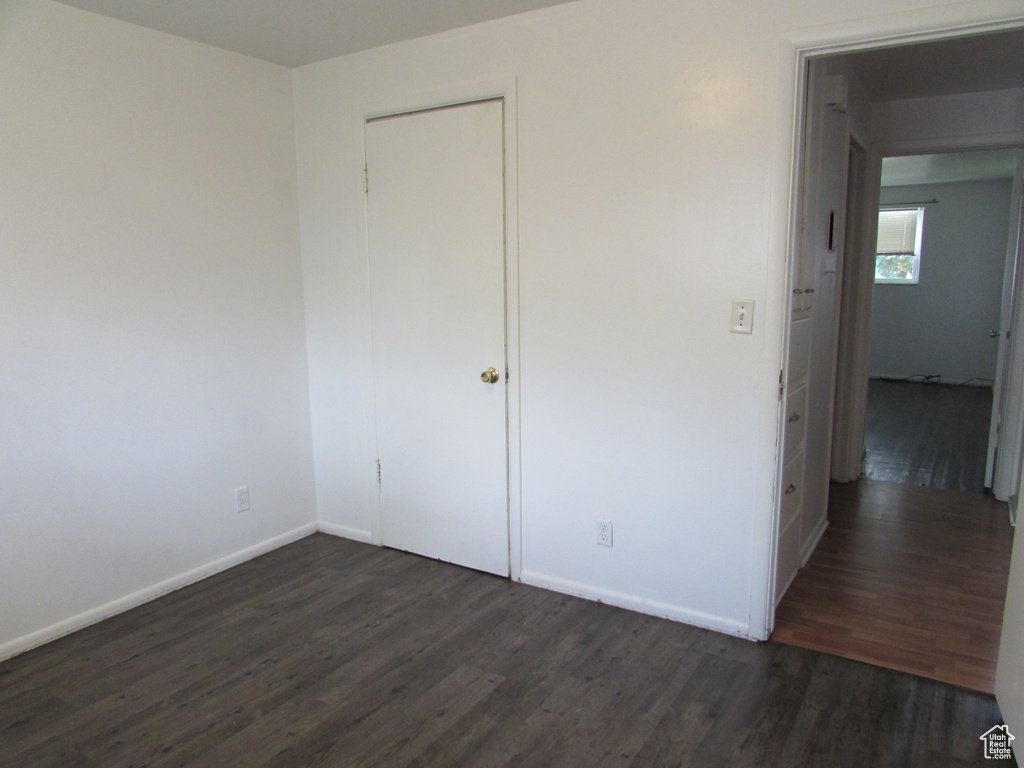 Unfurnished bedroom featuring dark wood-type flooring