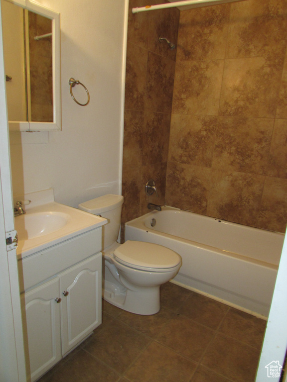 Full bathroom with toilet, tiled shower / bath combo, and vanity