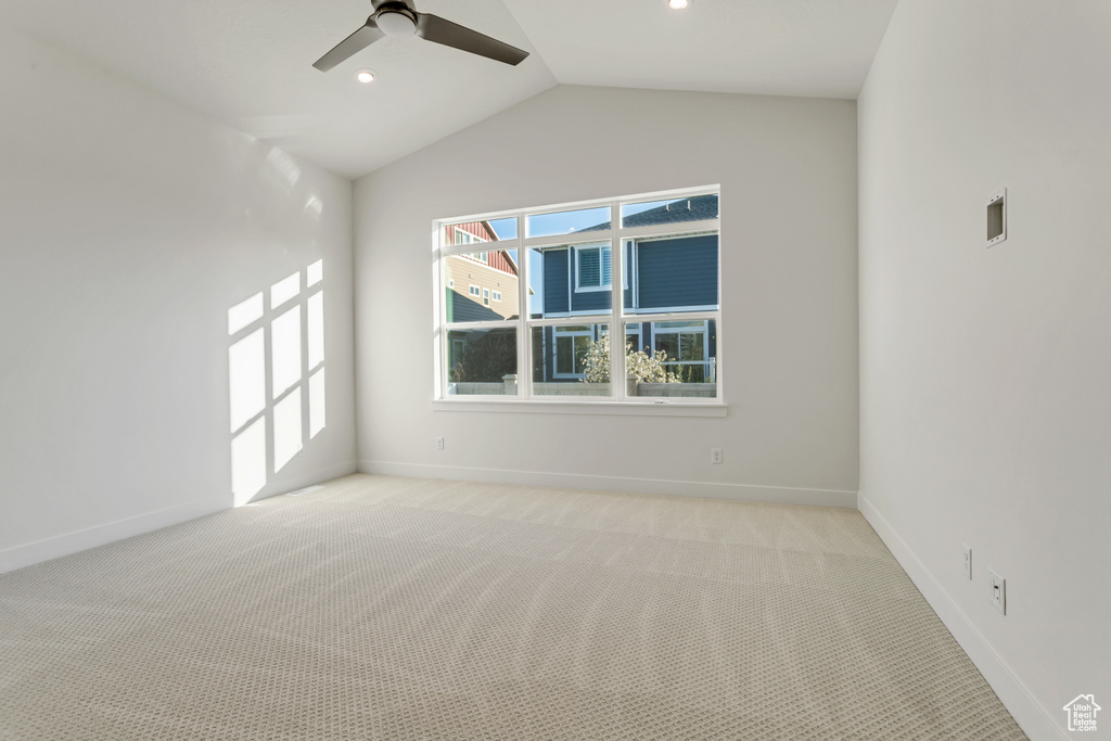 Unfurnished room featuring light carpet, ceiling fan, and lofted ceiling