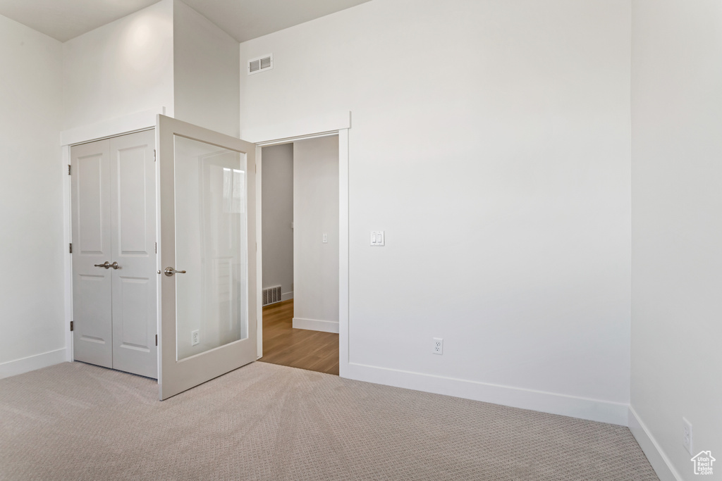 Unfurnished bedroom with light colored carpet
