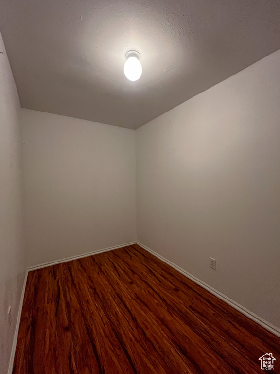 Empty room with dark wood-type flooring