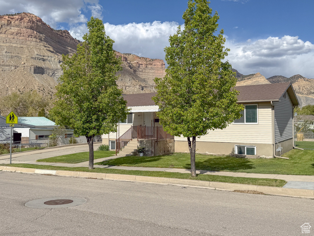 Obstructed view of property featuring a mountain view and a front yard