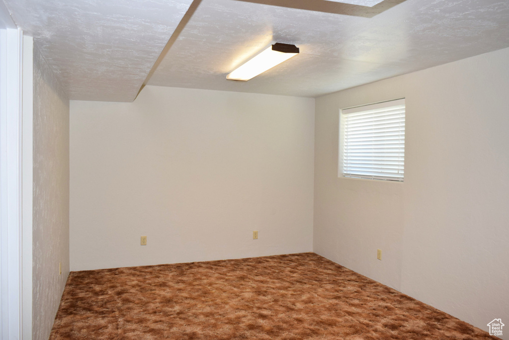 Carpeted spare room with a textured ceiling