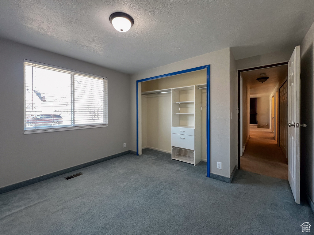 Unfurnished bedroom featuring carpet floors, a closet, and a textured ceiling