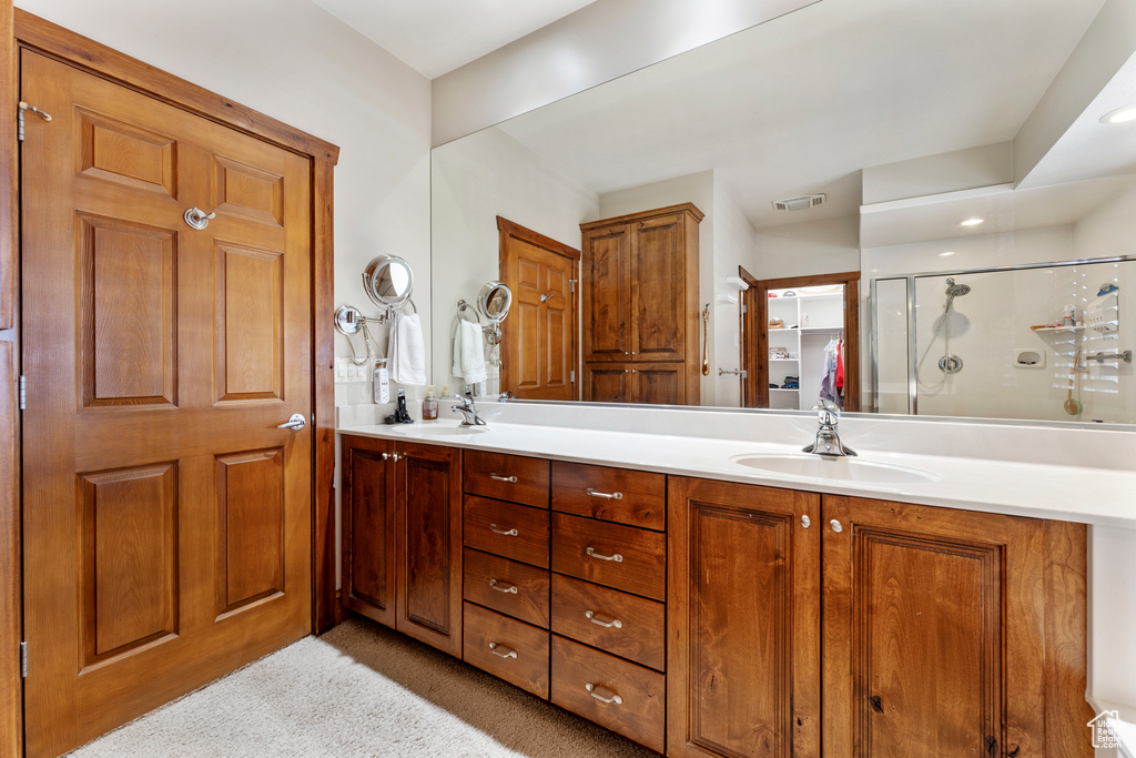 Bathroom with vanity and a shower with door