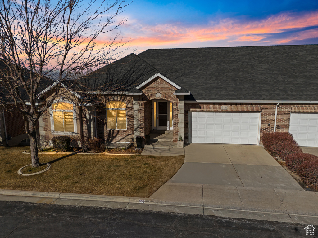 View of front of house featuring a garage and a lawn