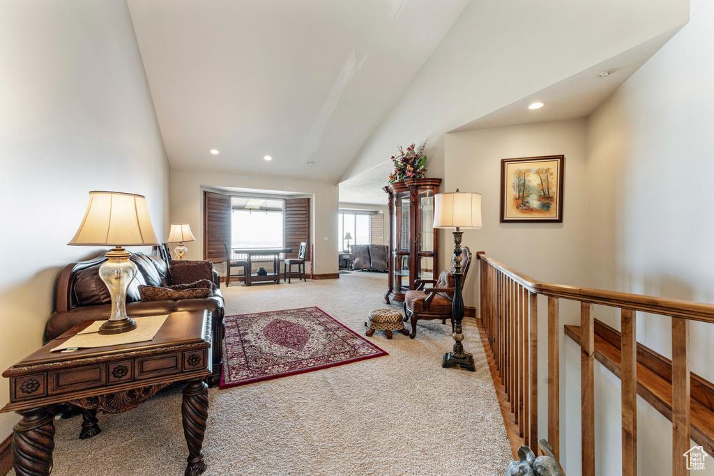 Living room featuring carpet flooring and vaulted ceiling