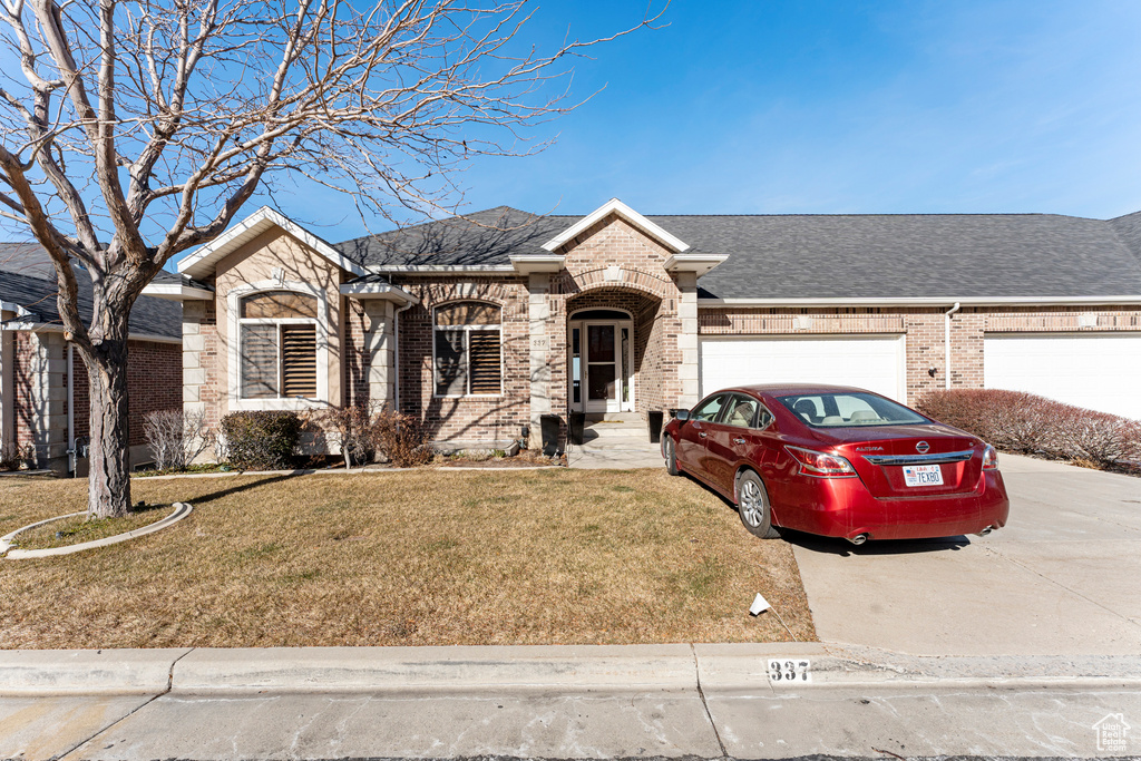 View of front of house with a garage and a front lawn