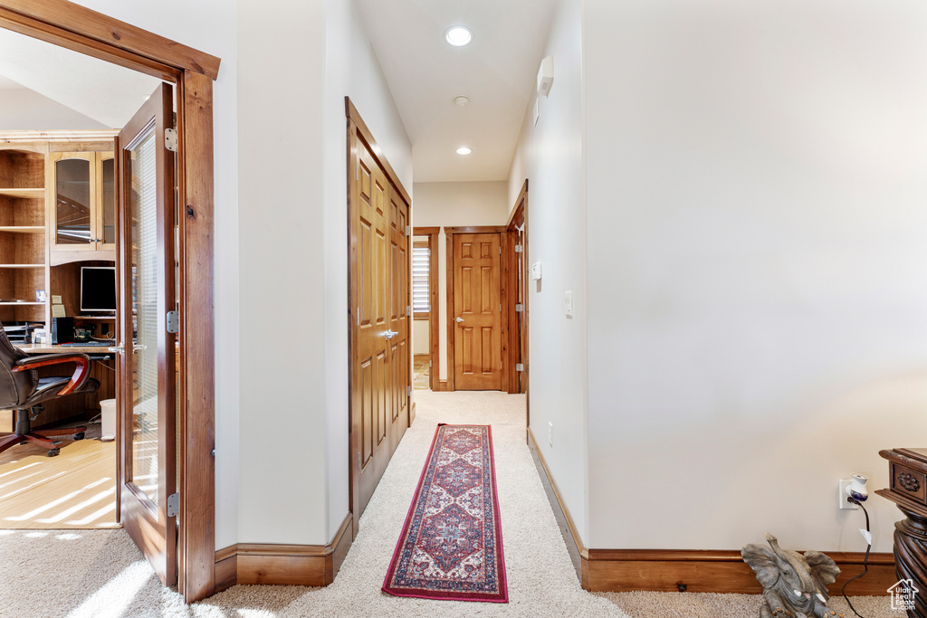 Corridor featuring light carpet