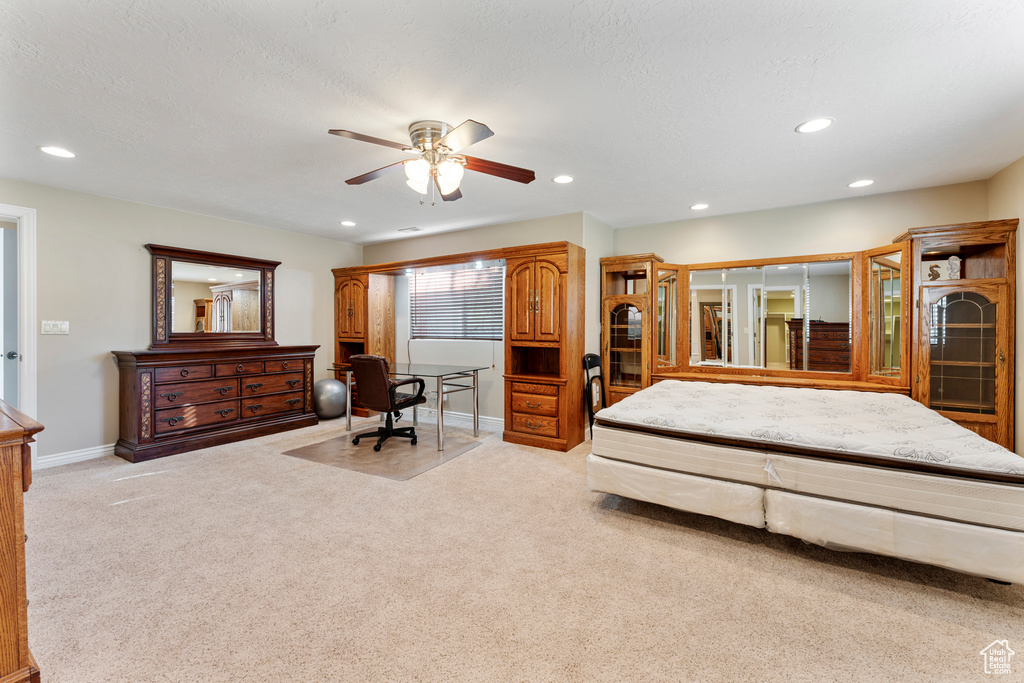 Bedroom with light carpet, a textured ceiling, and ceiling fan