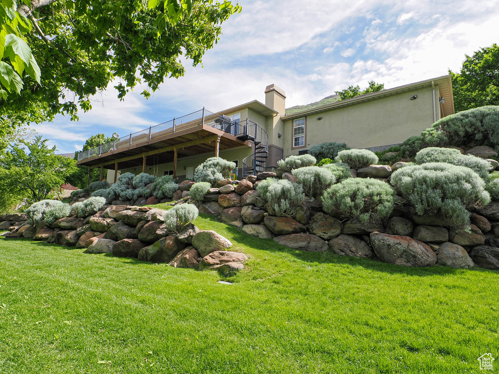 View of grassy yard with stairway and a deck