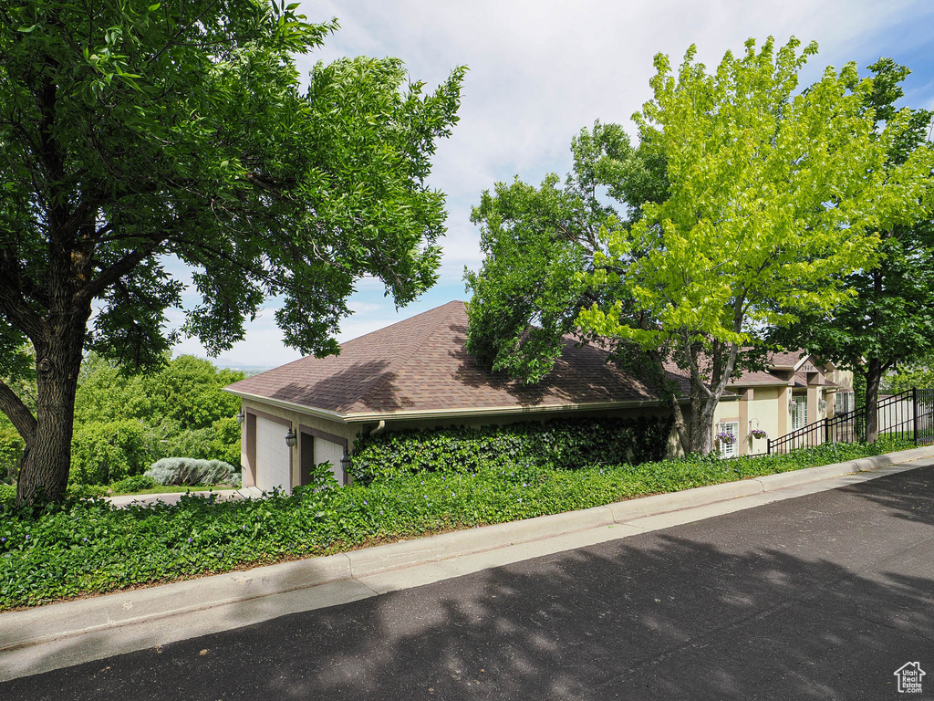 View of front of home featuring a garage and roof with shingles