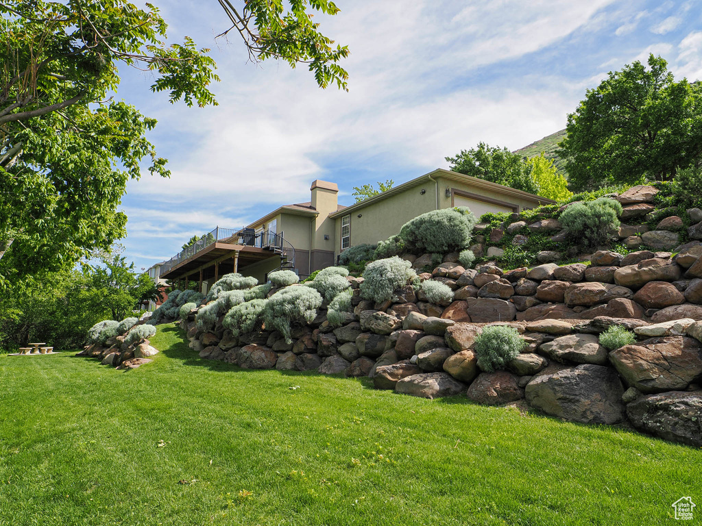 View of grassy yard featuring a deck