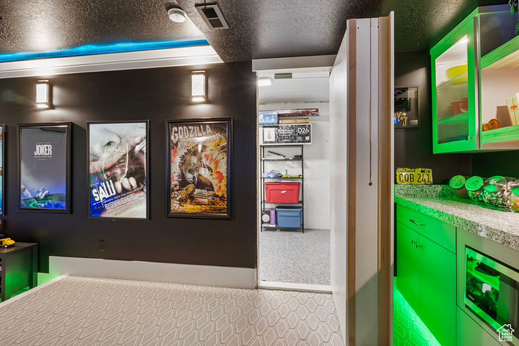 Details featuring carpet floors, a textured ceiling, and beverage cooler