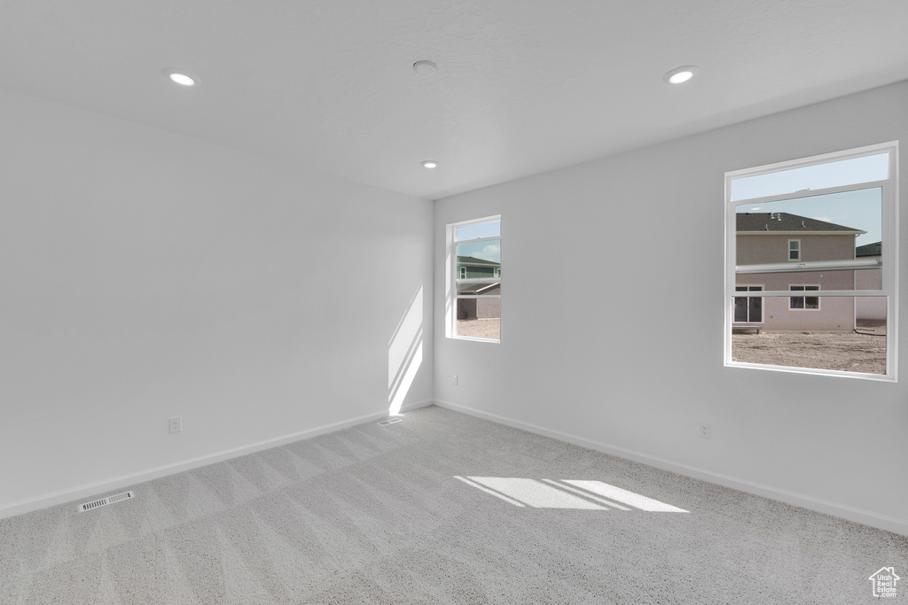 Carpeted spare room featuring baseboards and recessed lighting